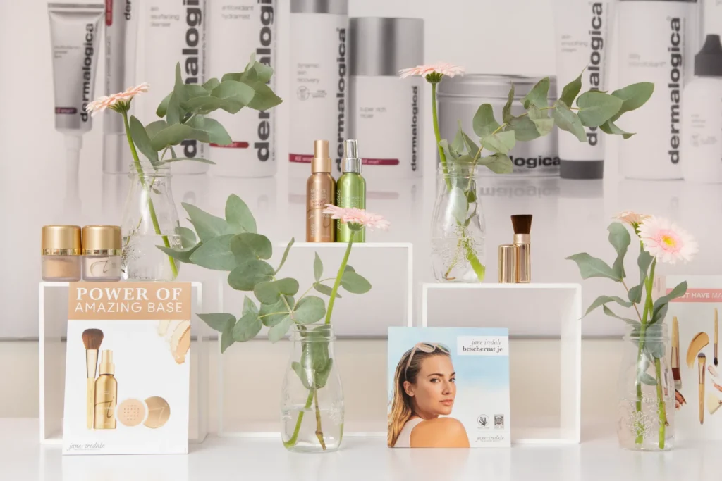 Huidverzorgende producten, drukwerk en planten gepresenteerd op tafel in salon Skin solutions