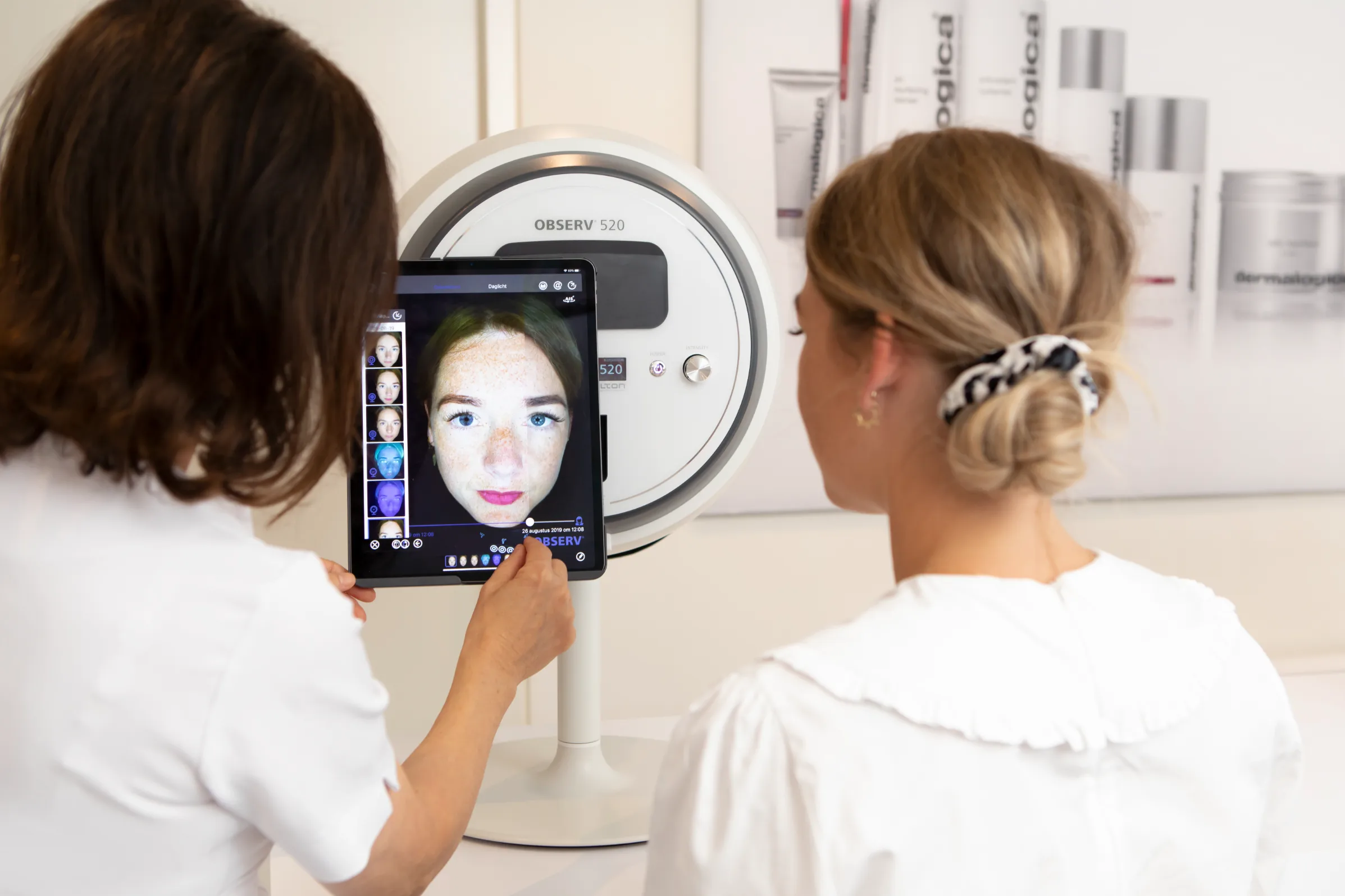 Twee schoonheidsspecialisten bekijken een huidanalyse op de Sqinno Observ 520
